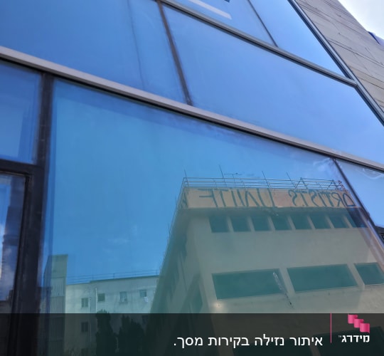 חלון זכוכית עם השתקפות בניין סמוך